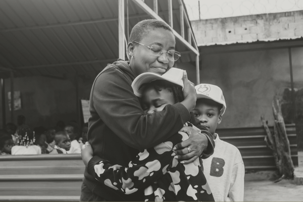 Adult hugging children representing family support resources